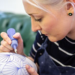 Rhian Malin decorating a mandala bottle in her workshop 2019